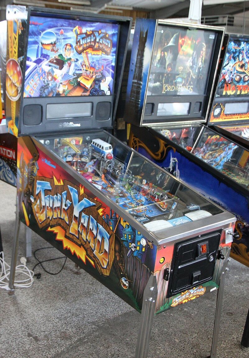 A complete Junk Yard machine: the backbox with the lit backglass above the cabinet with its graffiti-style side art.